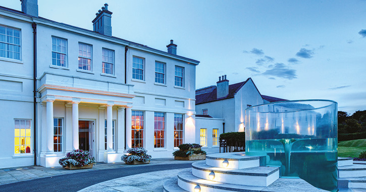 View of the exterior of Seaham Hall Hotel entrance with water fountain during early evening twilight